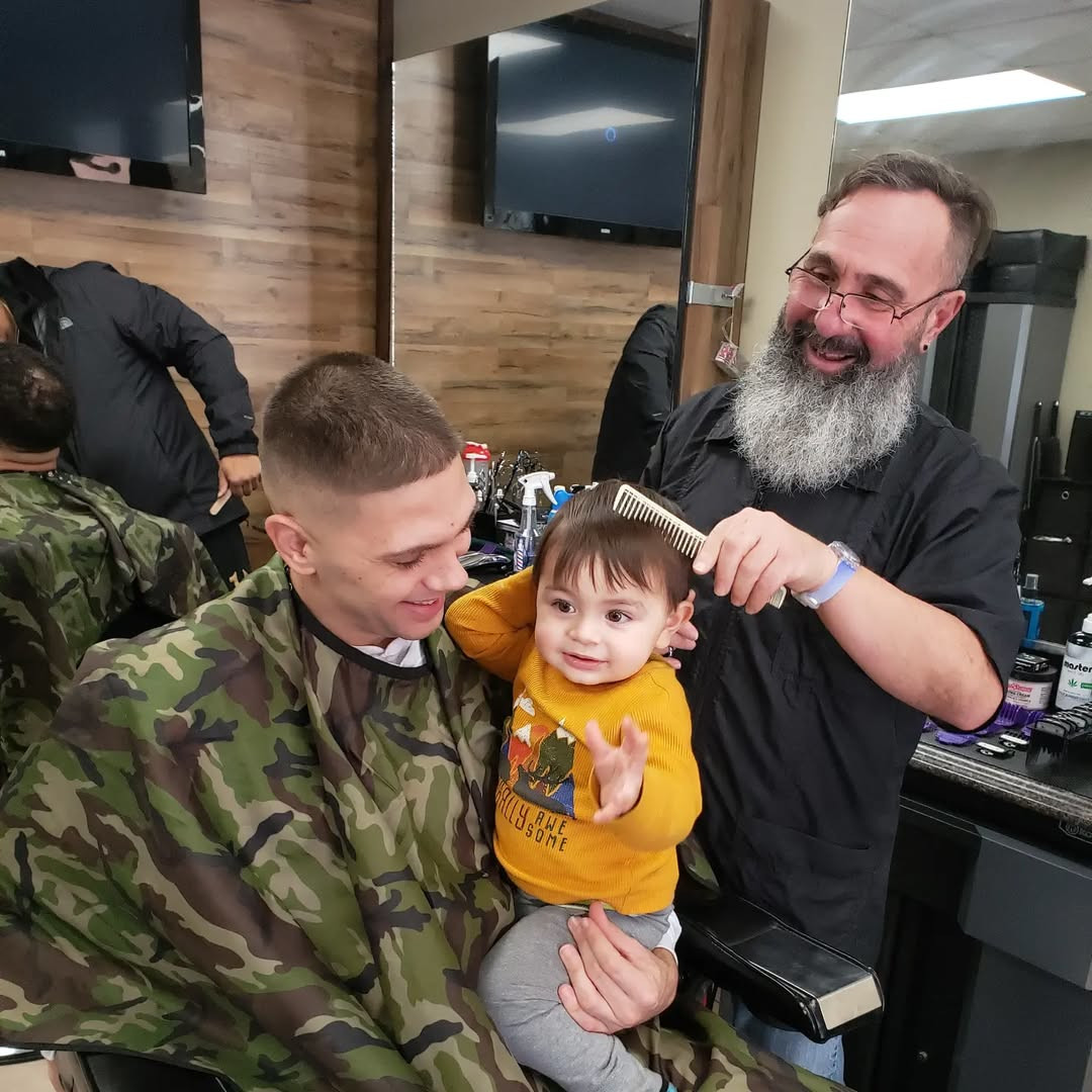 barber cutting a child’s hair at Atomic Salon